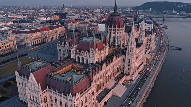 Fly around the top of the Parliament building in Budapest in the evening at sunset against the background of the Danube River