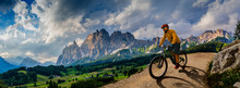 Man cycling on electric bike, rides mountain trail. Man riding on bike in Dolomites mountains landscape. Cycling e-mtb enduro trail track. Outdoor sport activity.
