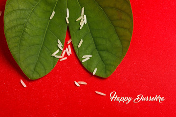 Happy Dussehra greeting card , green leaf and rice