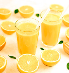 freshly squeezed orange juice in glasses on the kitchen table with slices of oranges, concept of diet and healthy lifestyle