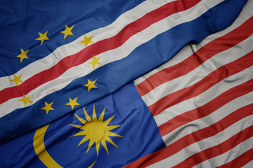 Obraz premium waving colorful flag of malaysia and national flag of cape verde.