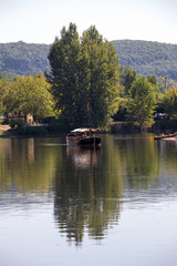 Beynac et Cazenac, Dordogne, France - September 4, 2018: Canoeing and tourist boat, in French called gabare, on the river Dordogne at La Roque-Gageac, Aquitaine, France