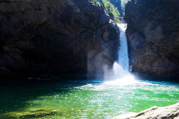 Wasserfall, der sich in leuchtend türkises Wasserbecken ergiesst