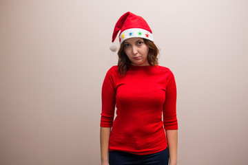 happy girl in santa hat in red blouse on white background 