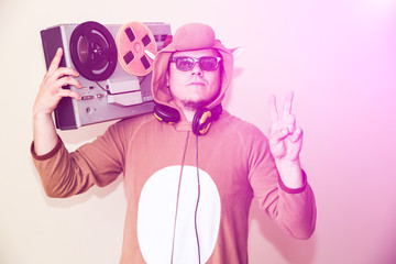 Man in cosplay costume of a cow with reel tape recorder. Guy in the animal pyjamas sleepwear. Funny...