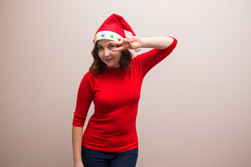 happy girl in santa hat in red blouse on white background 