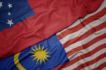 waving colorful flag of malaysia and national flag of Samoa .