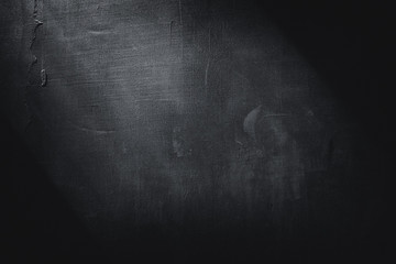 Abstract decorative textured dark black background with beautiful gray spots, strokes and stains. Texture of wall with decorative plaster on plywood, copy space.
