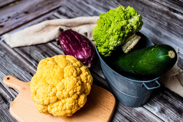 Chou-fleur jaune aubergine courgette chou romanesco sur une planche à découper, légumes bio du...
