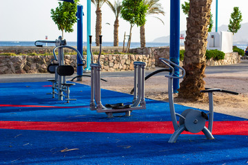 urban square district training apparatus  for sport activities on waterfront shoreline near sea with palm trees background
