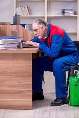 Old professional contractor doing pest control in the office