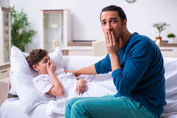 Obraz premium Young father caring for sick son