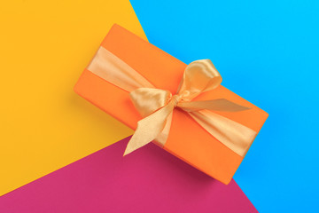 Gift box with ribbon and bow on color background and space for text. Top view - Image