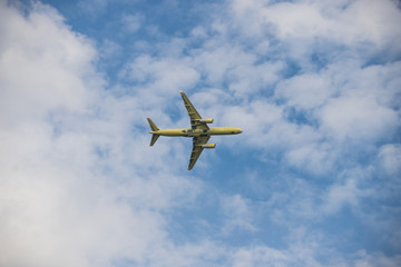 Big passenger plane flying in the cloudy sky