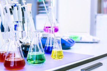 Chemical analysis, pharmacology and laboratory concept. Flasks with colored liquid reagents in a...