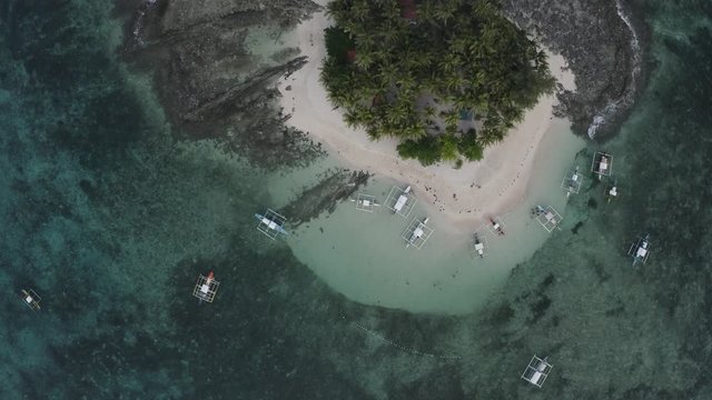 4K Aerial Drone footage of Guyam island Siargao Philippines . This shot is moving overhead showing the small paradise with ocean water and tropical palm trees