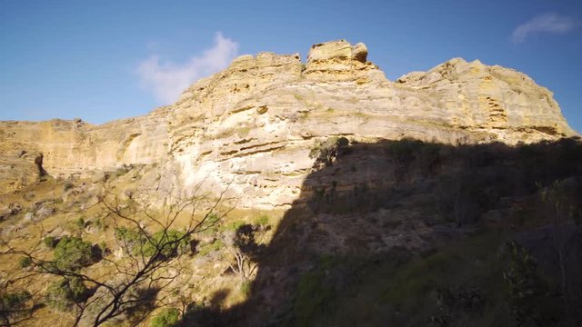 Isalo National Park, Madagascar. Clouds in the sky above the famous rock formation with grass plain on the foreground.