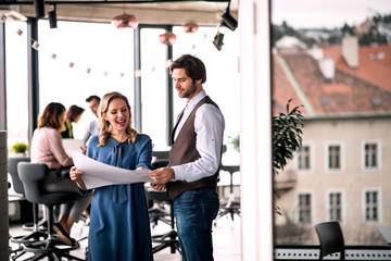 A group of young business people in an office, working.