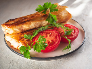 Plate with baked homemade sandwiches and red tomato halves