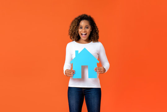 African American woman holding house model