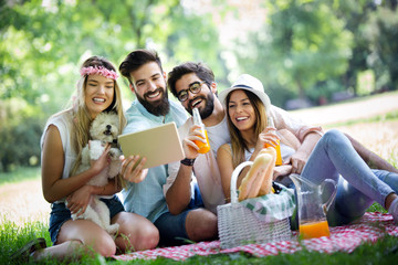 Group of young people taking a selfie outdoors, having fun