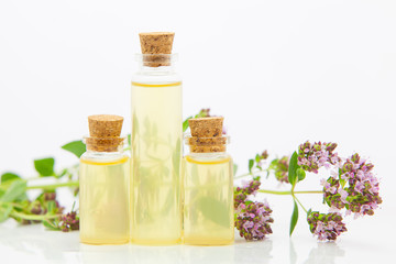 Essence of Oregano flowers on table in beautiful glass Bottle