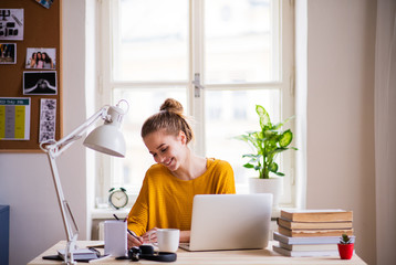 A young female student sitting at the table, studying.