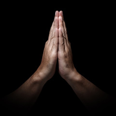 Man hands in praying position low key image. High Contrast isolated  on Black Background. Ratio 1:1