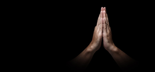 Man hands in praying position low key image. High Contrast isolated  on Black Background. Banner
