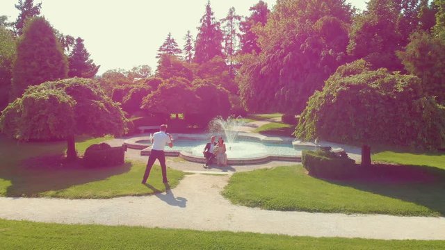 Romantic wedding photos in a beautiful park by the fountain. Aerial shot.