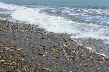 The wave rolls on the rocky shore.