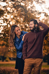 Fototapeta premium Couple in autumn season colored park enjoying outdoors.