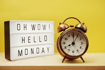 Hello Monday text in lightbox with alarm clock on Yellow background