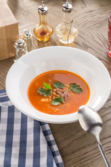 beef soup with tomato, carrot, onion and parsley and glass of red drink on wooden table
