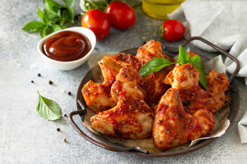 Tasty snack. Baked chicken wings with mustard tomato sauce on a concrete table. Free space for your text.