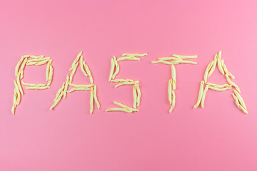 Word pasta made with italian pasta on pink background