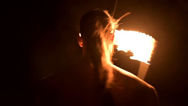 Fire show. Man juggles with two burning torches. Night show. Mastery of the fakir