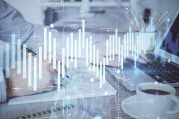 Multi exposure of stock market graph with man working on laptop on background. Concept of financial analysis.