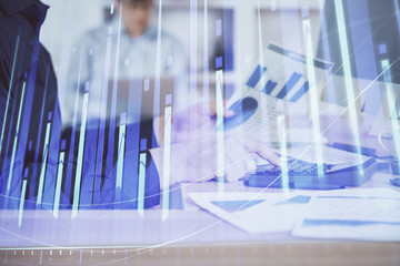 Double exposure of graph with man typing on computer in office on background. Concept of hard work. Closeup.