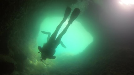 Large cave underwater with divers