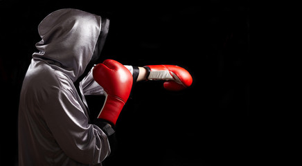 Boxer with red boxing glove is doing shadow boxing.