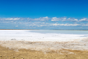 Camargue white salt flat lake, etang salt water lagoon surrounded by sand dunes, Southern France