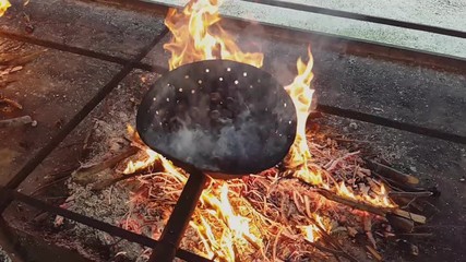 Steaming chestnuts cooking in a pair over the fire, Vittorio Veneto, Italy