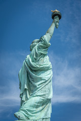 Fototapeta premium Shot of the Statue of Liberty in New York City, Usa. The shot is taken during a beautiful sunny day with a blue sky and white clouds in the background 