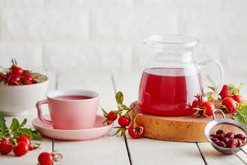 Cup of rose hip tea and fresh rose hips