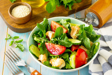 Concept for a tasty and healthy meal. Salmon Grilled Salad with cucumber, tomatoes, fresh arugula and sesame seeds. Home made food.