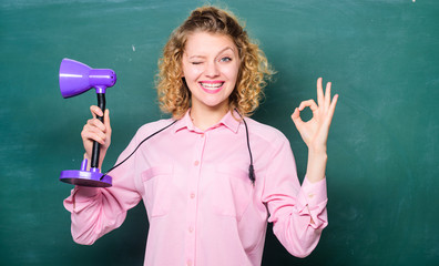 Knowledge day. Enlightenment concept. Creativity and inspiration. Turn light on. Proper light classroom. Light up process of studying. Insight and idea. Teacher hold table lamp chalkboard background