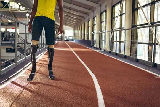 Disabled African American male athletic standing on running track in fitness center