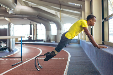 Side view of disabled young man exercising in gym
