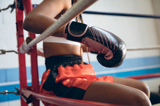 Midsection of boxer relaxing in boxing ring